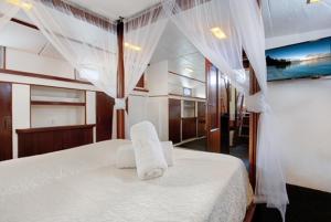 um quarto com uma cama branca com toalhas brancas em Charming Boat in Barcelona - Perfect getaway em Barcelona