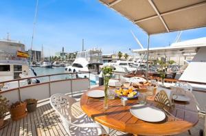 - une table et des chaises en bois sur un bateau dans l'établissement Charming Boat in Barcelona - Perfect getaway, à Barcelone