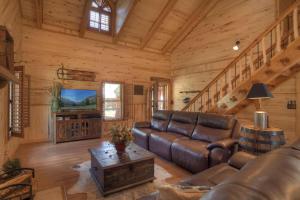 サウス・フォークにあるRustic A Cabinのリビングルーム(ソファ、テレビ付)が備わるログキャビンです。