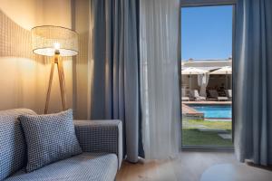 a living room with a couch and a window with a pool at Soas Suites in Alacati