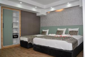 een slaapkamer met 2 bedden en een boekenplank bij My Sun Hotel in Izmir