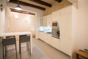La cuisine est équipée de placards blancs et d'un four avec plaques de cuisson. dans l'établissement Valletta most central studio apartment 16th-Century building, à La Valette