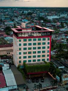 a large white building with a red sign on it at Grand Zuri Dumai in Dumai