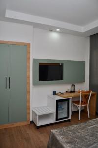 a room with a desk and a tv on a wall at My Sun Hotel in Izmir