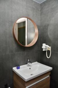 ein Bad mit einem Waschbecken und einem Spiegel in der Unterkunft My Sun Hotel in Izmir