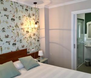 a bedroom with a bed with a floral wall at Las Palomas in O Porto de Espasante