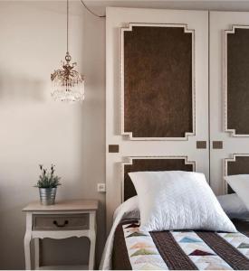 a bedroom with a bed and a table and a chandelier at Las Palomas in Porto de Espasante