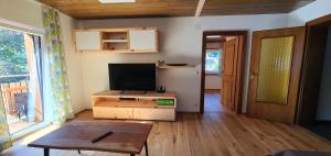 ein Wohnzimmer mit einem Flachbild-TV und einem Tisch in der Unterkunft Ferienwohnung Brader in Hallstatt