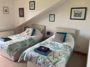 a bedroom with two beds and a staircase at Midkinleith Farm Holiday Cottage in Edinburgh