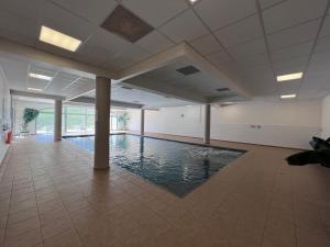 uma piscina num quarto grande com piso em azulejo em Duplex 8 couchages, au pied des pistes de la Mongie em La Mongie