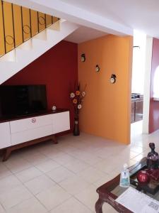 - un salon avec une télévision et un escalier dans l'établissement Casa Amplia a 5 Min del Centro en Zona Cerrada, à Tehuacán
