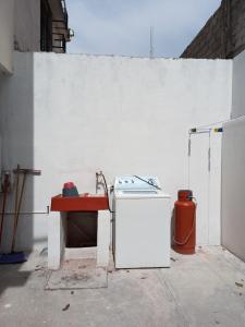 un mur blanc avec une cuisinière et une table dans l'établissement Casa Amplia a 5 Min del Centro en Zona Cerrada, à Tehuacán