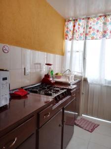 Il comprend une cuisine équipée d'une cuisinière. four supérieur à côté d'une fenêtre dans l'établissement Casa Amplia a 5 Min del Centro en Zona Cerrada, à Tehuacán