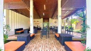 a restaurant with tables and chairs in a building at Kuapa Resort in Takua Pa