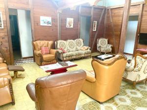 a living room with leather chairs and couches at Maison de 3 chambres avec piscine partagee jardin clos et wifi a Sainte Anne a 8 km de la plage in Sainte-Anne