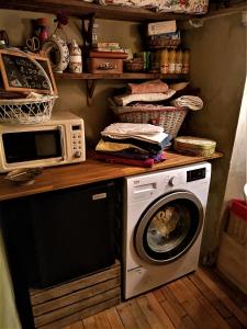 een keuken met een wasmachine en een magnetron bij Chambre avec vue in Saignon