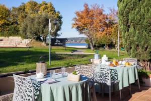 una mesa con mesas blancas y sillas en un parque en HÖTEL LE CASTELLAN, en Istres