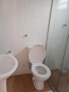 a bathroom with a toilet and a sink at Pousada Delícias do Mar in Pirenópolis