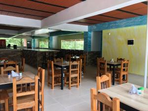 un ristorante con tavoli e sedie in legno e un bar di Hotel Jireh - San Carlos Ant a San Carlos