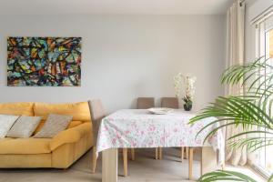 une salle à manger avec une table et un canapé jaune dans l'établissement Apartamento Columbretes, à San Juan de Alicante