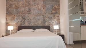 - une chambre avec un lit blanc et 2 lampes dans l'établissement Valletta most central studio apartment 16th-Century building, à La Valette