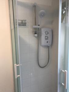 a shower with a shower head in a bathroom at Poplar Lodge, Dee Valley Stays - cosy microlodge with detached private shower & WC in Corwen