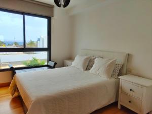 een slaapkamer met een bed en een groot raam bij Villa Gabriel (private Spa-Jacuzzi) in Costa Teguise