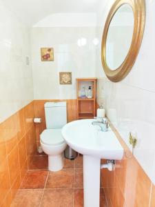 een badkamer met een toilet, een wastafel en een spiegel bij Villa Gabriel (private Spa-Jacuzzi) in Costa Teguise