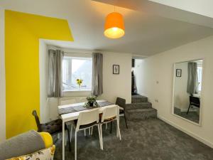 a living room with a table and a yellow wall at Heritage House By MGroupSA - Free Parking in Nantyglo