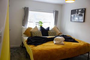 sypialnia z żółtym łóżkiem i oknem w obiekcie Heritage House By MGroupSA - Free Parking w mieście Nantyglo
