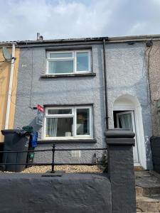 ein graues Gebäude mit einem Fenster und einer Tür in der Unterkunft Heritage House By MGroupSA - Free Parking in Nantyglo