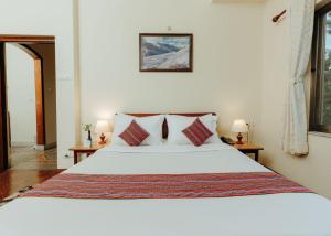 a bedroom with a large white bed with pillows at Tise Hotel in Kathmandu