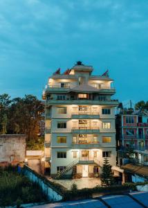 a tall white building with lights on at Tise Hotel in Kathmandu