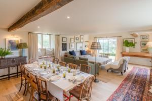 a dining room and living room with a table and chairs at Locks Cottage in Cheltenham