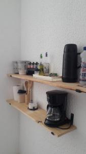 a kitchen shelf with a coffee maker on it at Espaço do Adilson é aconchegante in Rio de Janeiro