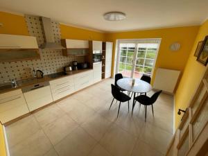 a kitchen with a table and chairs in a room at Fewo am Teich in Laage