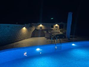 a large swimming pool at night with a patio at Fewo am Teich in Laage