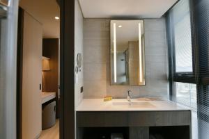 a bathroom with a sink and a mirror at CHECK inn Select New Taipei Sanchong in Taipei