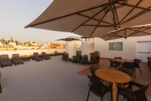 a patio with tables and chairs and umbrellas at Casa Andina Standard Arequipa in Arequipa