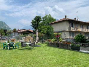 a yard with a table and chairs and a house at Acchiappasogni Holiday House in Malgrate