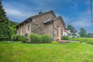 a stone house with a flag in a yard at Cozy Wrightsville Cottage with Private Hot Tub! in Wrightsville