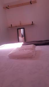 a bedroom with a white bed and a mirror at Espaço do Adilson é aconchegante in Rio de Janeiro