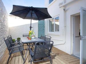 einen Tisch und Stühle mit Sonnenschirm auf einer Terrasse in der Unterkunft Suzie's Pad Torquay Devon in Torquay