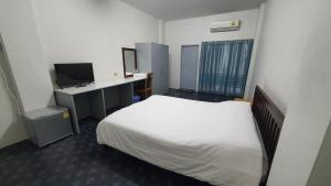 Habitación de hotel con cama y TV en Monta Apartment, en Bang Saen