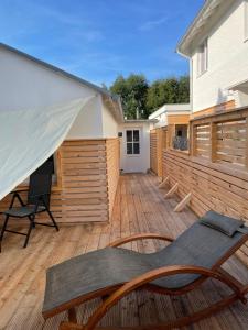 a patio with a table and chairs on a wooden deck at Relitto Sommerhaus in Borkum