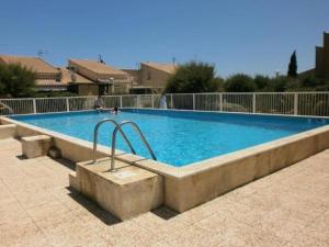 a large swimming pool with blue water at New Maison tout confort, bord de mer avec Parking Privé in Gruissan