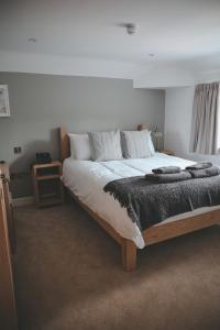 a large bed with white sheets and pillows on it at The Canal in Whatstandwell