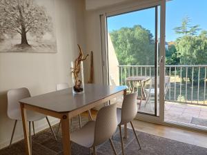 a dining room with a table and chairs and a balcony at Eaton in Saint Malo