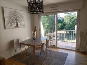 a dining room with a table and chairs and a large window at Eaton in Saint Malo