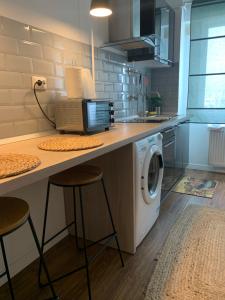 a kitchen with a counter with a washing machine at Apartament Claudia -self check-in in Brăila